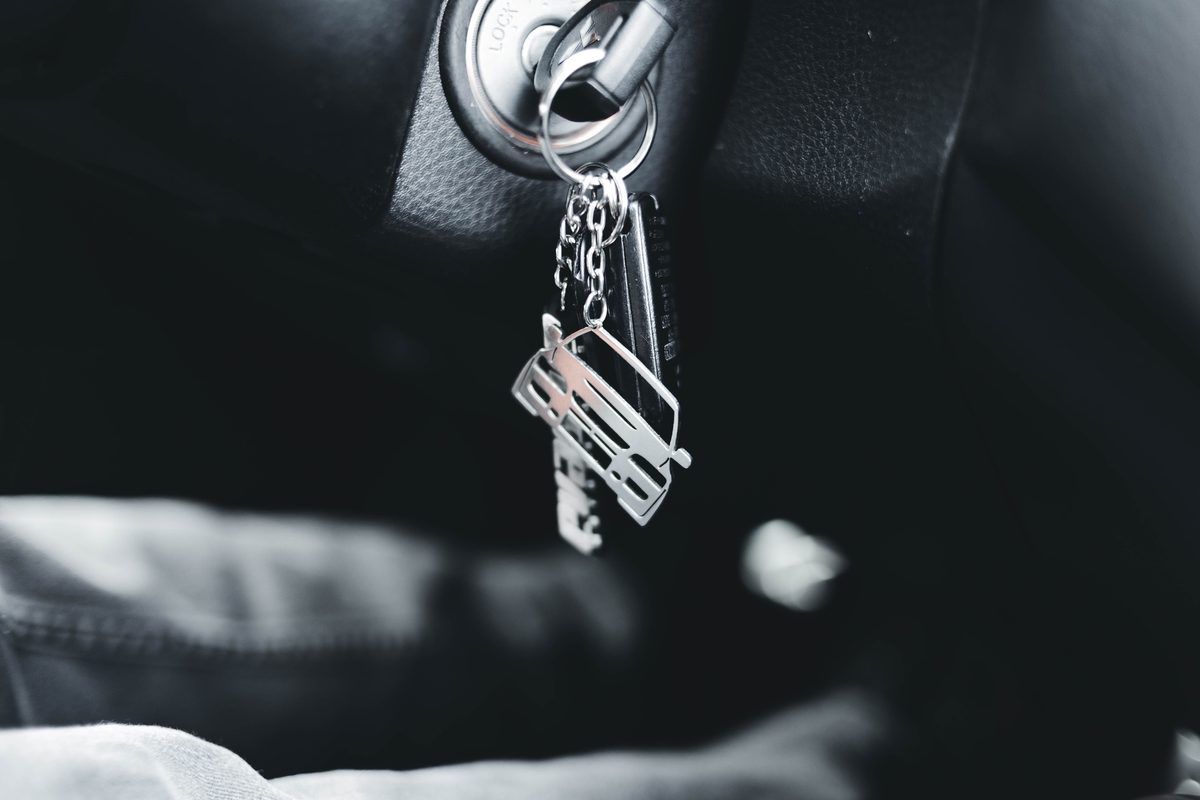 Car key with a car-shaped keychain in the ignition — the moment a six-year auto loan starts